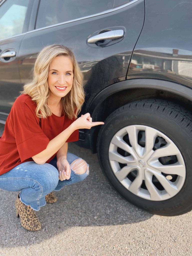 Brooke pointing to her car tire
